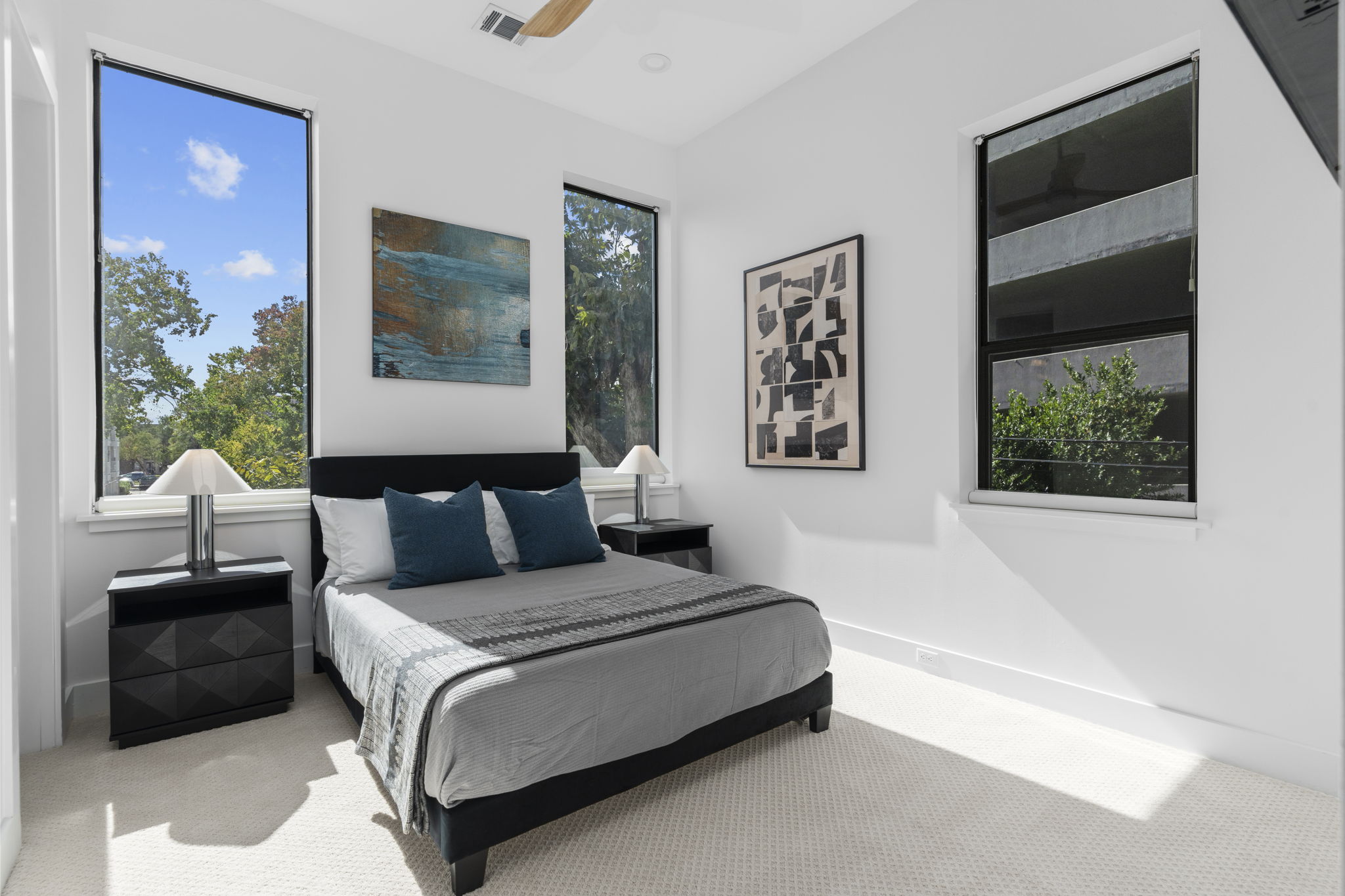 Bedroom with grey bedding and tall windows